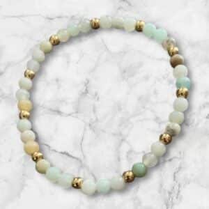 Bracelet Douceur Aqua en Amazonite brute avec perles multi 4 mm et séparateurs dorés, sur fond marbré blanc.