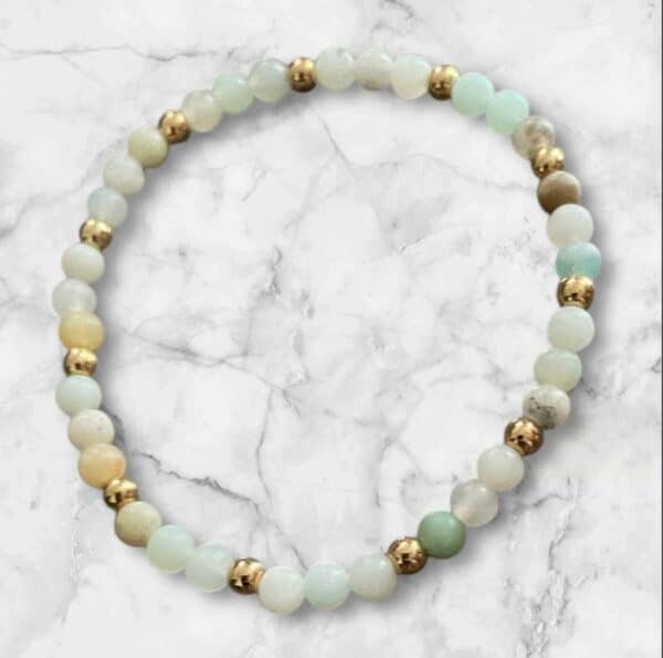 Bracelet Douceur Aqua en Amazonite brute avec perles multi 4 mm et séparateurs dorés, sur fond marbré blanc.